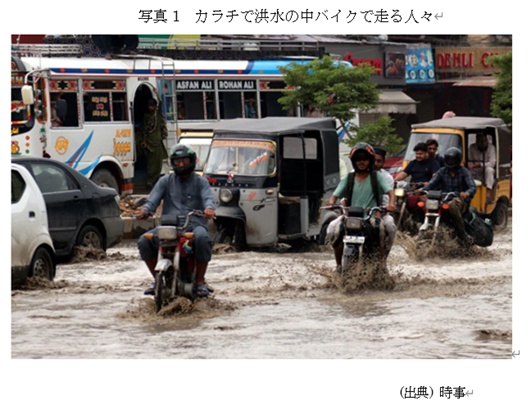 写真1 カラチで洪水の中バイクで走る人々